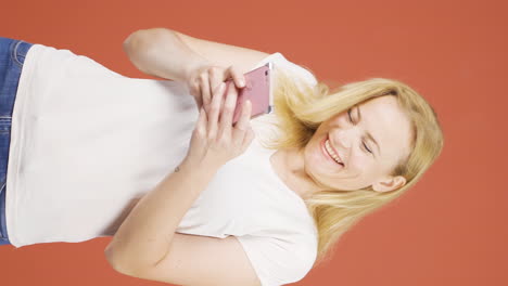Vertical-video-of-Happy-woman-texting-on-the-phone.-Smiling.